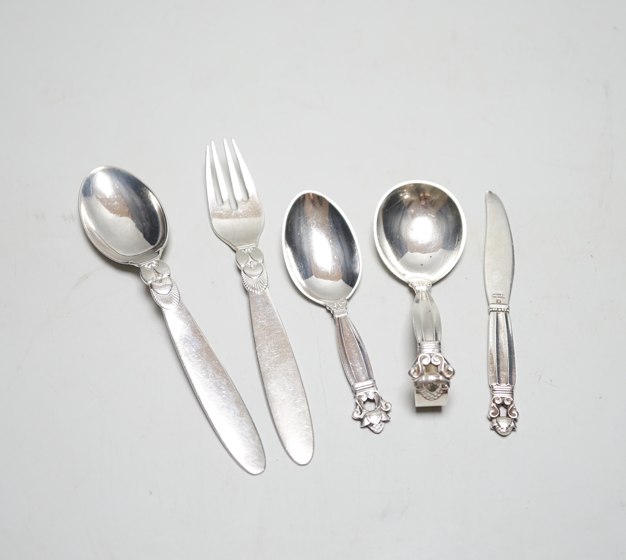 Five assorted items of Georg Jensen flatware including christening fork and spoon, caddy spoon, etc.